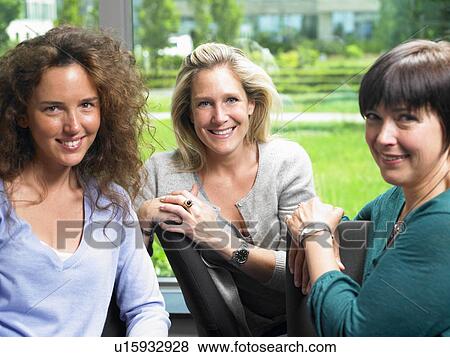 Stock Photo - Women looking at camera, smiling. Fotosearch