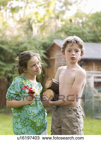 Stock Image - young boy and girl set up home in garden. Fotosearch