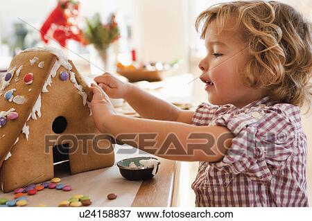Stock Photo - Young boy baking cake house. Fotosearch