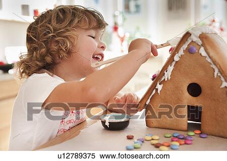 Stock Photography - Young boy baking cake house. Fotosearch