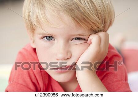 Stock Photograph - young boy looking bored at viewer. Fotosearch
