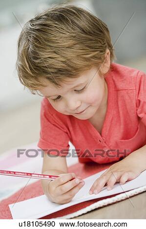 Stock Image - young boy on floor painting with pen. Fotosearch
