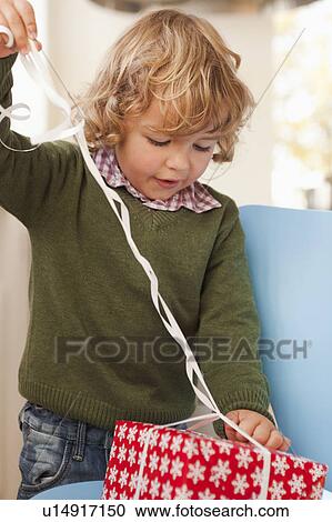 Young boy opening christmas present View Large Photo Image Stock Image - Young boy opening christmas present. Fotosearch