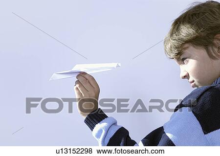 young boy playing with paper airplane View Large Photo Image Stock Photo - young boy playing with paper airplane. Fotosearch