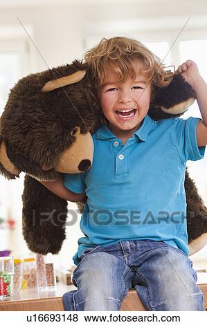 Young boy playing with teddy bear View Large Photo Image Stock Photo - Young boy playing with teddy bear. Fotosearch