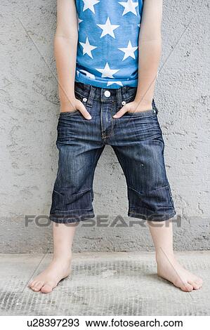 Stock Image - young boy standing at wall. Fotosearch