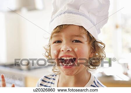 Stock Image - Young boy with flour in his face. Fotosearch