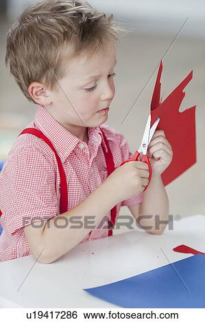 young boy with paper and scissors View Large Photo Image Stock Photograph - young boy with paper and scissors. Fotosearch