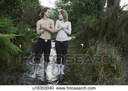 Young couple standing in stream View Large Photo Image Stock Image - Young couple standing in stream. Fotosearch