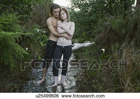 Young couple standing in stream View Large Photo Image Stock Photograph - Young couple standing in stream. Fotosearch