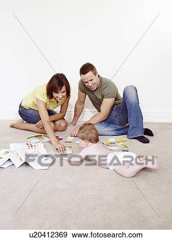 Stock Photo - Young family on floor with color samples. Fotosearch