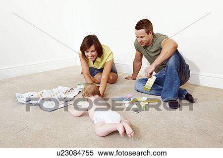 Stock Photography - Young family on floor with color samples. Fotosearch
