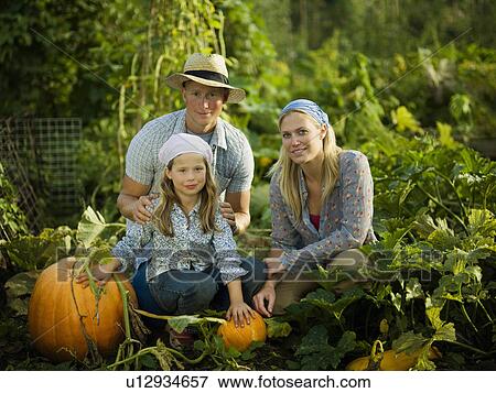 Stock Photo - Young family with some pumpkins. Fotosearch