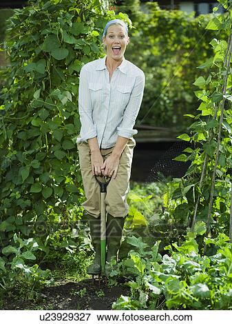 Stock Photo - Young female working in a garden. Fotosearch