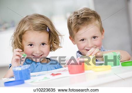 Stock Photography - young girl and boy playing with colours. Fotosearch