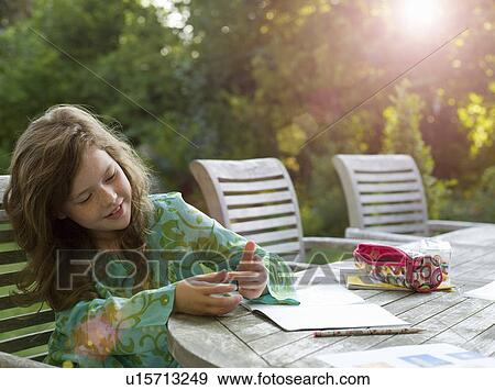 Stock Photo - Young girl counting on fingers in garden. Fotosearch