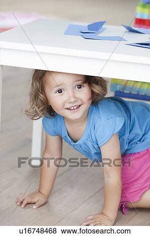 young girl crawling under table View Large Photo Image Stock Photo - young girl crawling under table. Fotosearch