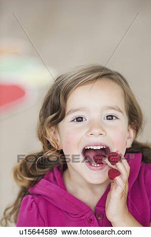 young girl eating berries from fingers View Large Photo Image Stock Photo - young girl eating berries from fingers. Fotosearch