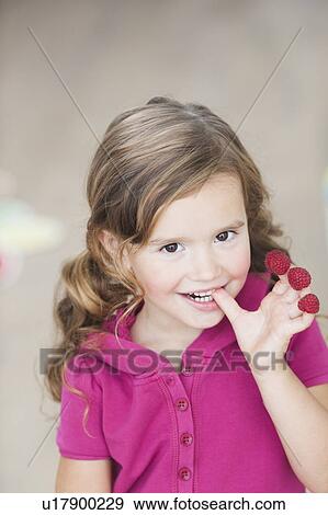 young girl eating berries from fingers View Large Photo Image Stock Photo - young girl eating berries from fingers. Fotosearch