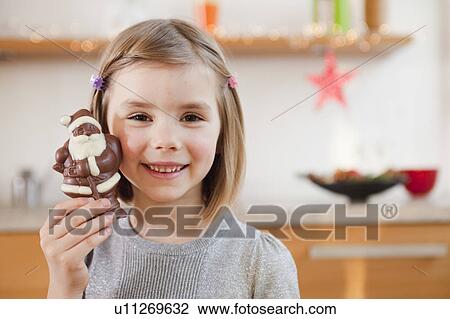 young girl holding chocolate santa claus View Large Photo Image Stock Image - young girl holding chocolate santa claus. Fotosearch