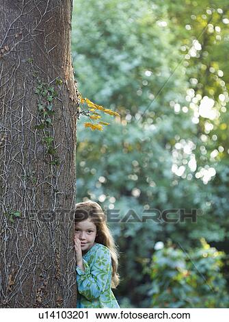 Young girl leaning on tree in garden View Large Photo Image Stock Image - Young girl leaning on tree in garden. Fotosearch