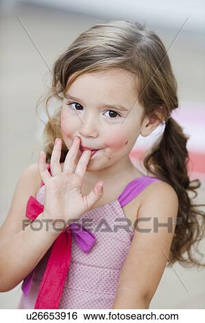 Stock Photograph - young girl licking her fingers. Fotosearch