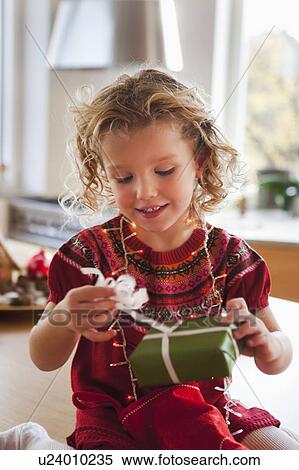 young girl opening present smiling View Large Photo Image Stock Photography - young girl opening present smiling. Fotosearch