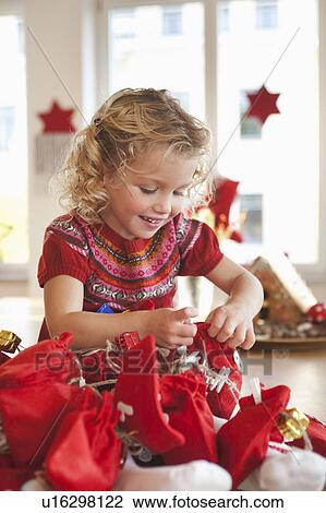 Stock Image - young girl playing with gift sacks. Fotosearch