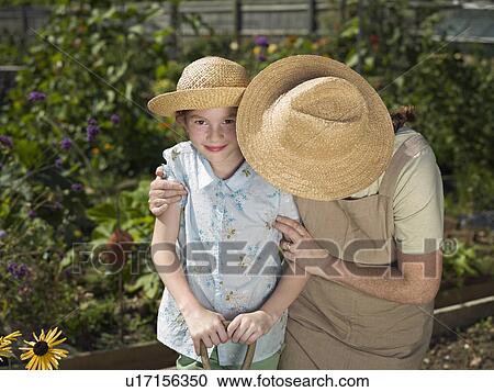 Young girl smiling with mother in garden View Large Photo Image Stock Image - Young girl smiling with mother in garden. Fotosearch
