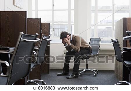 Young man at a workstation, worried View Large Photo Image Stock Image - Young man at a workstation, worried. Fotosearch
