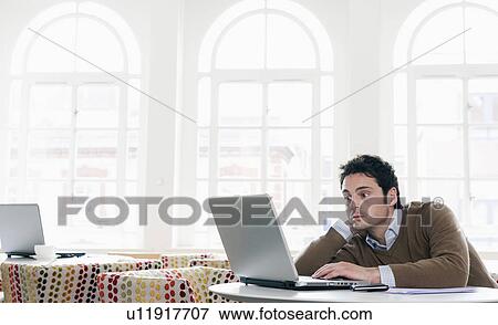 Young man gazing into laptop View Large Photo Image Stock Photo - Young man gazing into laptop. Fotosearch
