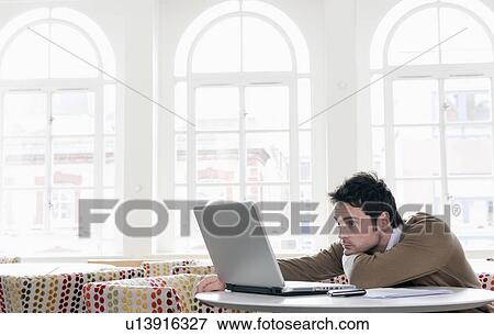 Stock Photo - Young man gazing into laptop. Fotosearch