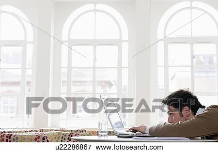 Young man gazing into laptop View Large Photo Image Stock Photo - Young man gazing into laptop. Fotosearch