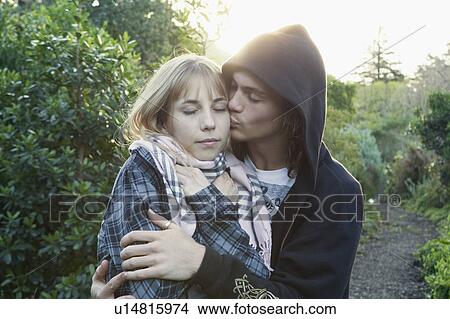 Young man kissing young woman View Large Photo Image Picture - Young man kissing young woman. Fotosearch