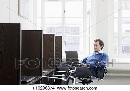 Young man working at a work station View Large Photo Image Picture - Young man working at a work station. Fotosearch