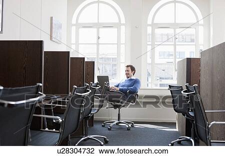Stock Image - Young man working at a work station. Fotosearch