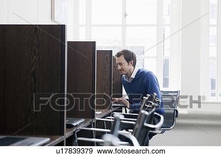 Young man working at a work station View Large Photo Image Stock Photo - Young man working at a work station. Fotosearch