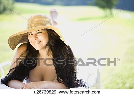 young plump girl lying on a sun lounger View Large Photo Image Stock Photo - young plump girl lying on a sun lounger. Fotosearch