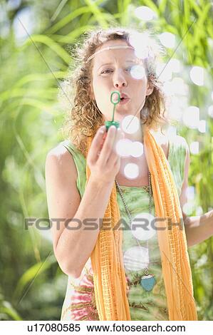 Stock Photography - young woman blowing bubbles. Fotosearch