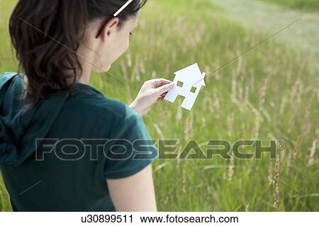 Young woman holding cut-out paper house View Large Photo Image Stock Image - Young woman holding cut-out paper house. Fotosearch