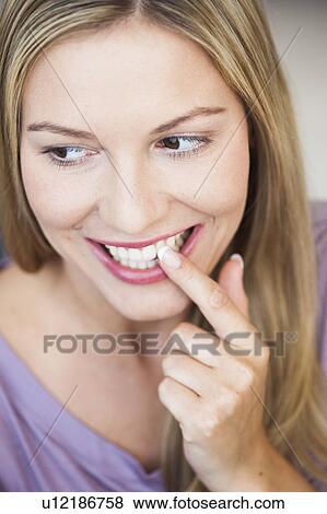 Young woman pointing at her teeth View Large Photo Image Stock Photo - Young woman pointing at her teeth. Fotosearch