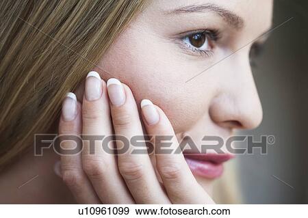 Young woman resting head on hand View Large Photo Image Stock Photo - Young woman resting head on hand. Fotosearch
