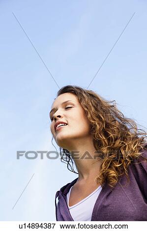 Stock Photo - young woman under blue sky. Fotosearch