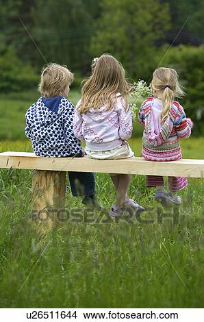 3 children sitting on a bench. View Large Photo Image Picture - 3 children sitting on a bench.. Fotosearch