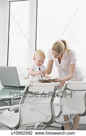 A baby with a colleague on a laptop View Large Photo Image Stock Image - A baby with a colleague on a laptop. Fotosearch