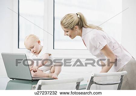 Stock Image - A baby with a laptop and a colleague. Fotosearch