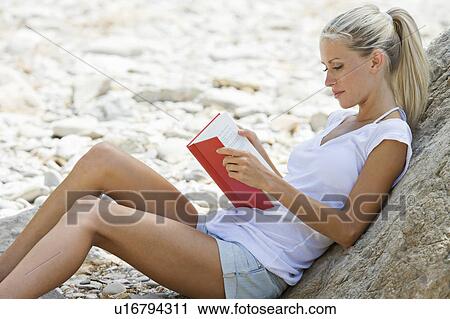 A blond beach girl with a book View Large Photo Image Stock Image - A blond beach girl with a book. Fotosearch