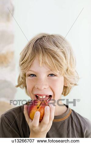 Stock Photo - A boy eating a nectarine. Fotosearch