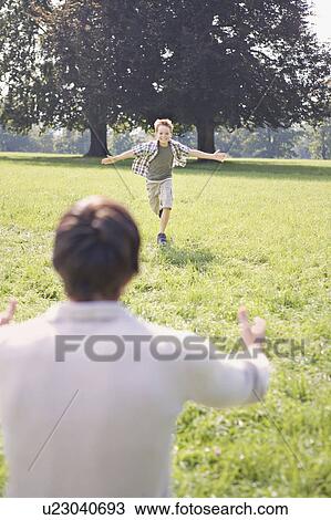 A boy running to his father in the park View Large Photo Image Stock Image - A boy running to his father in the park. Fotosearch