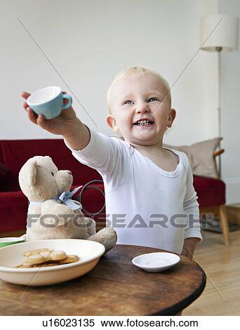 A boy toddler holding out a tea cup View Large Photo Image Stock Photography - A boy toddler holding out a tea cup. Fotosearch